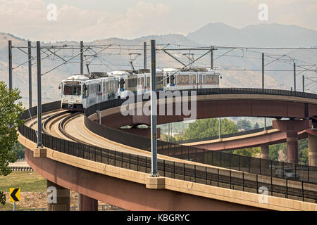 Lakewood, Colorado - un treno su 'w' linea di denver il sistema di transito rapido attraversa una superstrada. Il trasporto regionale opera del distretto di Nove ra Foto Stock