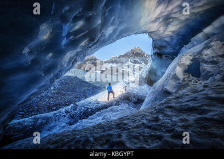 Fotografo all'interno di una caverna di ghiaccio durante una spedizione di fotografia in Ghiacciaio Athabasca Foto Stock