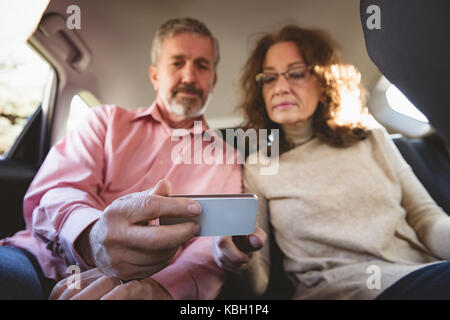 Giovane utilizzando il telefono cellulare in auto Foto Stock
