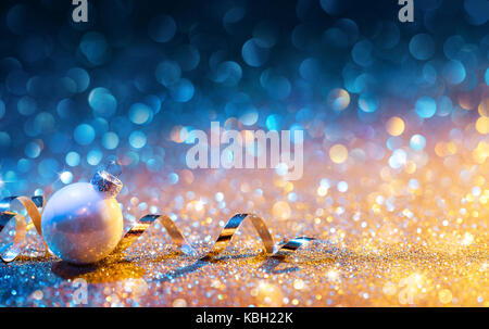 Addobbi natale su glitter - bokeh golden blu con palla e streamer Foto Stock