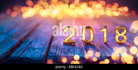 2018 - felice anno nuovo - golden numeri sul tavolo sfocati e luci bokeh di fondo Foto Stock