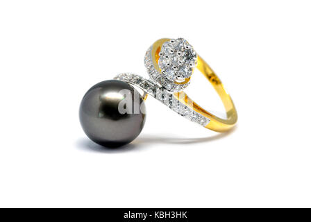 Chiuso dark pearl con diamante e anello oro isolati su sfondo bianco, anello di nozze e il concetto di amore. Foto Stock