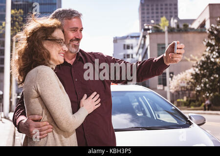 Felice coppia senior prendendo un selfie sulla strada Foto Stock