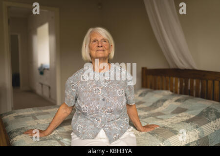 Premurosa donna senior rilassante sul letto in camera da letto Foto Stock