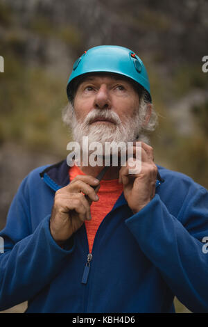 Close-up di senior uomo che indossa il casco di protezione Foto Stock