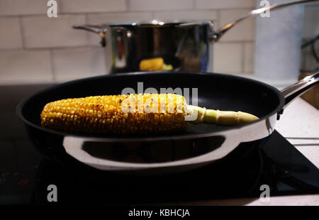 Granturco dolce sulla pannocchia di mais carbonizzazione in una padella per grigliare Foto Stock