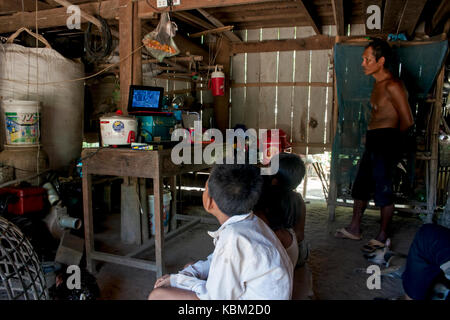 Un uomo è la visione di anni cinquanta la versione di cenerentola su un lettore cd insieme con il prossimo i bambini del villaggio in Kampong Cham provincia, in Cambogia. Foto Stock
