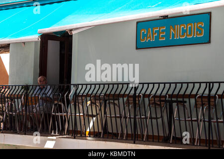 Corsica: un vecchio uomo seduto a tavoli all aperto di cafe nicois, uno dei più famosi bar e ristoranti del centro storico di Bonifacio Foto Stock