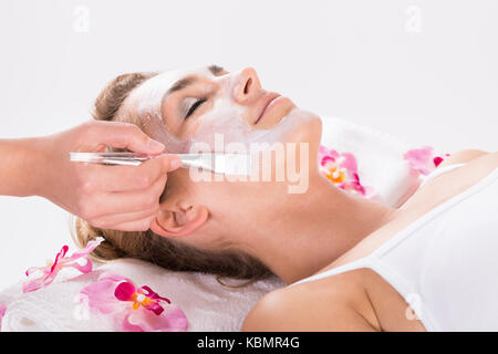 Immagine ritagliata di estetista applicato la maschera su clienti faccia a salon Foto Stock