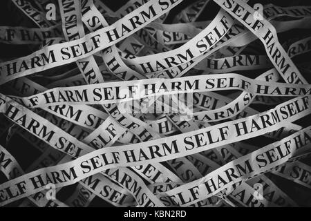 Carta sgualcita pezzi con parole self harm. close up. Foto Stock