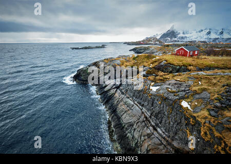 Clif con tradizionale rosso rorbu casa sulle isole Lofoten in Norvegia Foto Stock