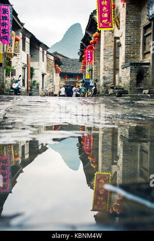 Huzhou, Cina - 3 maggio 2017: Huang yao città antica strada di zhaoping county, provincia di Guangxi. formazione carsica riflessa nell'acqua di pioggia Foto Stock