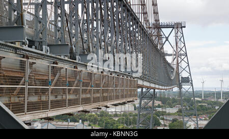 Vista lungo al di fuori del lato meridionale del pianale superiore di Newport Transporter Bridge, mostrando gondola ruote di trasporto su rotaia e lieve flessione nella struttura. Foto Stock