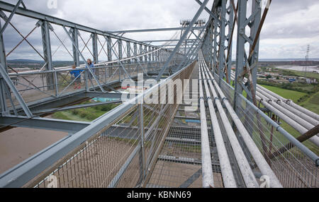 Vista verso est dal punto intermedio lungo il lato meridionale di ponte superiore passerella pedonale di Newport Transporter Bridge, che mostra i cavi di controventatura, e 2 visitatori Foto Stock