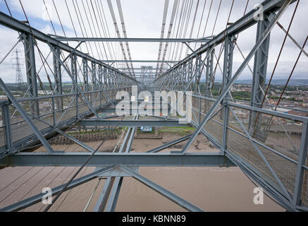 Vista lungo upper deck di Newport Transporter Bridge guardando ad ovest, mostra percorsi pedonali, il cavo resta, cavi di sospensione e il fiume Usk in seguito. Foto Stock