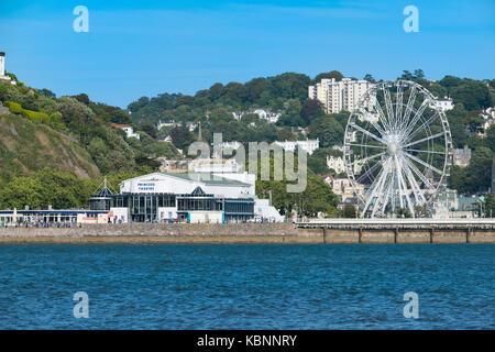 Il Princess Theatre e la Riviera Wheel di Torquay, Devon, Regno Unito, visti dall'acqua di Tor Bay in una soleggiata giornata estiva. Costa di pesce Foto Stock