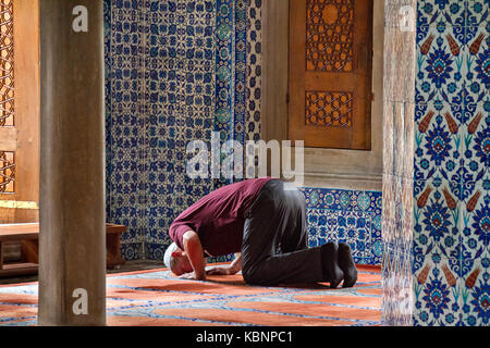 Uomo locale che prega nella Moschea di Rustem Pasha, a Istanbul, Turchia. Foto Stock