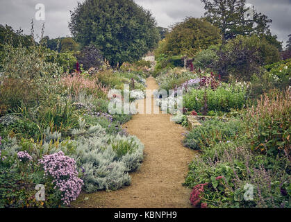 Un informale sentiero di ghiaia attraverso un grande giardino cottage Foto Stock