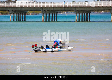 L'uomo la pesca al largo un sandbar in Wallis lago a Forster sulla mezza costa nord del Nuovo Galles del Sud, Australia Foto Stock