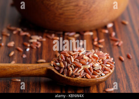 Il riso rosso sul cucchiaio di legno Foto Stock