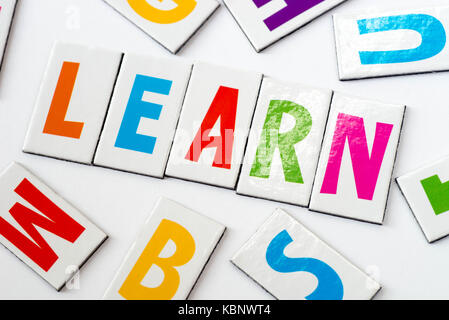 Parola imparare fatti di lettere colorate su sfondo bianco Foto Stock