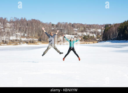 Happy amici di saltare sul lago ghiacciato Foto Stock