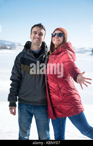 Coppia felice su un lago ghiacciato su una giornata invernale Foto Stock