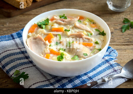 Pollo e riso selvatico zuppa. in casa fresca zuppa cremosa con pollo e verdure e riso selvatico nella ciotola bianco vicino. Foto Stock