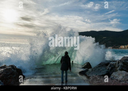 Giovane uomo circondata dalle onde del mare, Monterosso, 5 terre, Italia Foto Stock