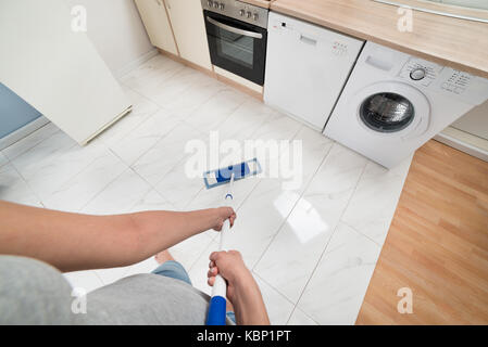Close-up di Donna di pulizia piano cottura con mop Foto Stock