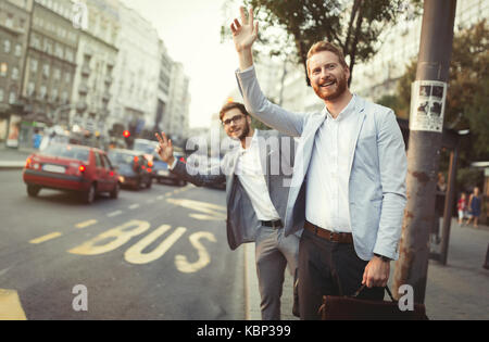 Gli uomini d' affari salutando una cabina nella città di occupato Foto Stock