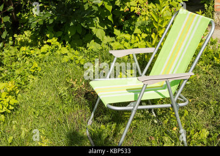 Sedia pieghevole per il campeggio sul prato verde. Foto Stock