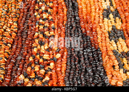 Perline di ambra di vari colori per la vendita sul mercato lituano. Foto Stock