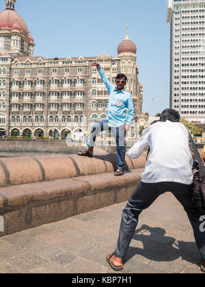 Un uomo in posa per una foto di strada con il Taj Mahal Hotel di Mumbai Foto Stock