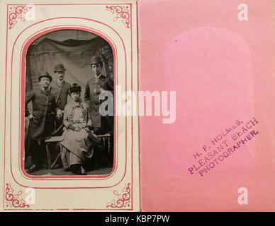 Archivio americano monocromatico ritratto in studio su tintype nel manicotto di carta di Charles Reynolds Hadden, dal porto Byron, NY, STATI UNITI D'AMERICA con due uomini che indossano medaglie e una donna di nome come Haddens, prese nel tardo XIX secolo Foto Stock