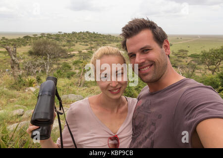 Coppia adulta prendendo selfie sulla natura africana safari nel Serengeti National Park, Tanzania Africa. Foto Stock