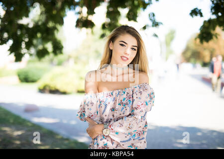 Bella slim ragazza bionda con una bella passeggiata nel parco dopo il lavoro Foto Stock