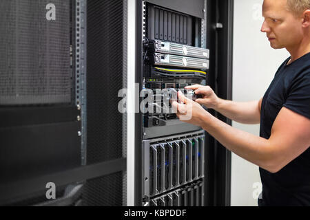 Consulente IT monitora i server nel centro dati Foto Stock