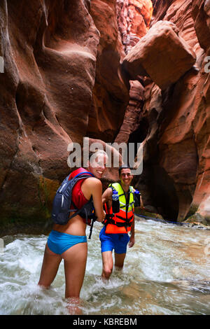 Coppia giovane sotto il big rock presso il Canyon di Wadi Mujib, Giordania Foto Stock