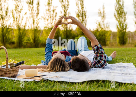 Coppia felice in amore, giacente sul parco e godersi la giornata insieme Foto Stock