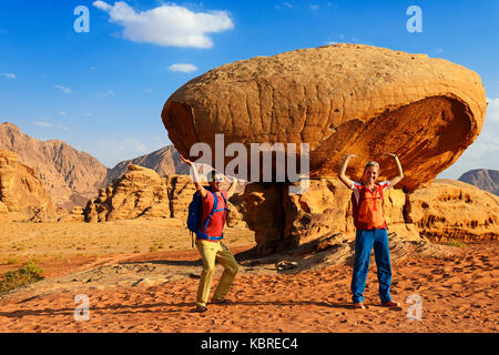 I turisti pongono a Mushroom-Rock, Al Fetra, Wadi Rum, Giordania Foto Stock