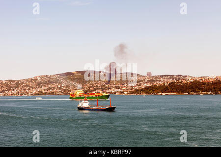 Grandi petroliere e navi passando Bosphorus Istanbul e un incendio nelle colline Foto Stock