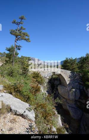 Walker Crossing Humpback Bridge, il Pont de Sautet (1787), sul fiume Jabron, vicino Trigance, nel Verdon Gorge Regional Park Provenza Francia Foto Stock