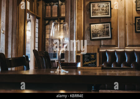 Interno della Eagle pub di Cambridge, vuoto bicchiere di vino sul tavolo. Aperto nel 1667 l'aquila è uno dei più grandi pub in Cambridge Foto Stock