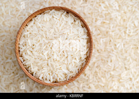 Cibo sano. ciotola di legno riempito lungo il riso parboiled su sfondo sfocato. close up, vista dall'alto, alta risoluzione prodotto. Foto Stock