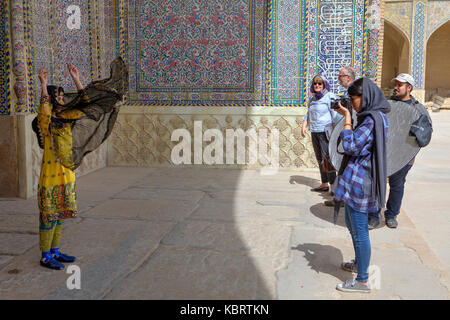 Far provincia, Shiraz, Iran - 19 aprile, 2017: una fotografia di sparare in aria aperta accanto a una moschea, una donna in nazionale costume iraniano è fotografata da Foto Stock