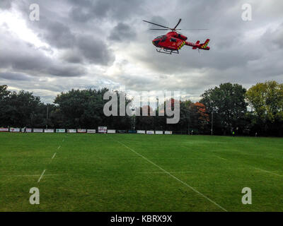 Woodford Green, Londra, Regno Unito. Il 30 settembre 2017. London's Air Ambulance elicotteri G-LNDN lascia Woodford Rugby Football Club Highams massa nel Woodford Green dopo aver partecipato a uno spettatore soffre di un attacco di cuore. Il Woodford v Chelmsford match è stato sospeso per 40 minuti mentre i paramedici hanno partecipato alla vittima che era in grado di uscire dalla strada. Woodford è andato a vincere la partita. La Air Ambulance è supportato da Londra massoni. Credito: Mark Dunn/ Alamy Live News Foto Stock