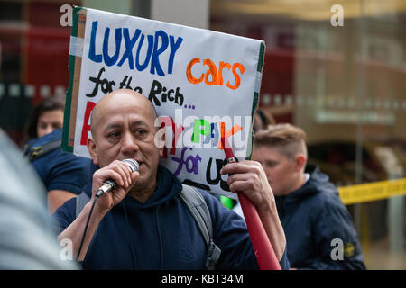 Londra, Regno Unito. 30 settembre, 2017. cleaner fredy Lopez, sospeso senza pagare con la sua partner angelica valencia bolanos dal contraente templewood pulizia per aver aderito sindacato United voci del mondo e per aver votato allo sciopero per il london salari, indirizzi sostenitori per protestare al di fuori di un'auto di lusso concessionario h.r. owen ferrari showroom in South Kensington. i pulitori, una coppia sposata, sono il solo responsabile di detergenti per la pulizia di h.r. owen di Ferrari e Maserati showroom via contraente templewood pulizia. Credito: mark kerrison/alamy live news Foto Stock