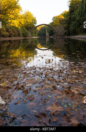 Bad Muskau, Germania. 29Sep, 2017. Il ponte rakotz e alberi in autunno colori vengono riflesse in un lago in un parco a Bad Muskau, Germania, 29 settembre 2017. Credito: Monika skolimowska/dpa-zentralbild/dpa/alamy live news Foto Stock