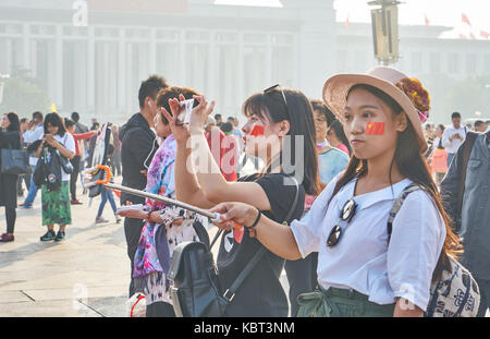 Piazza Tiananmen, Pechino, Cina. 1 ottobre, 2017. due ragazze vestito di rosso per scattare delle foto di fronte alla grande cesto fiorito installazione su Piazza Tiananmen, Pechino, Cina, sulla Cina Giornata nazionale del 2017, il primo ottobre del credito: Liao Yi/alamy live news Foto Stock